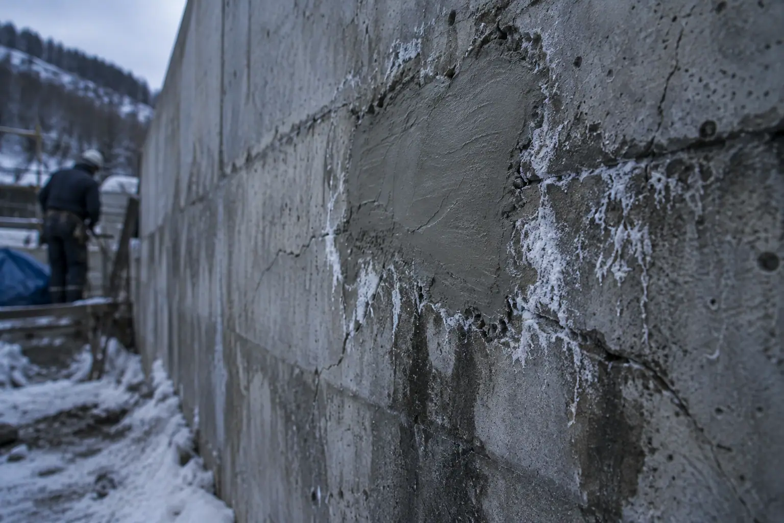 表面だけ補修した跡のまわりから、再びにじみ出るひび割れと白い析出物
